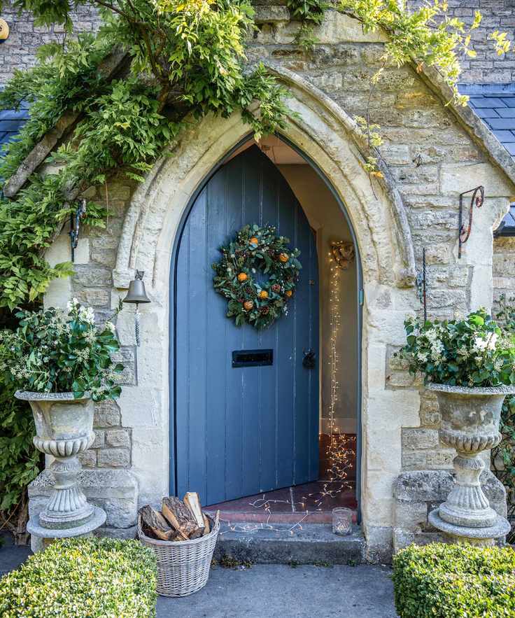 Gothic style front door adorned with a wreath and lights
