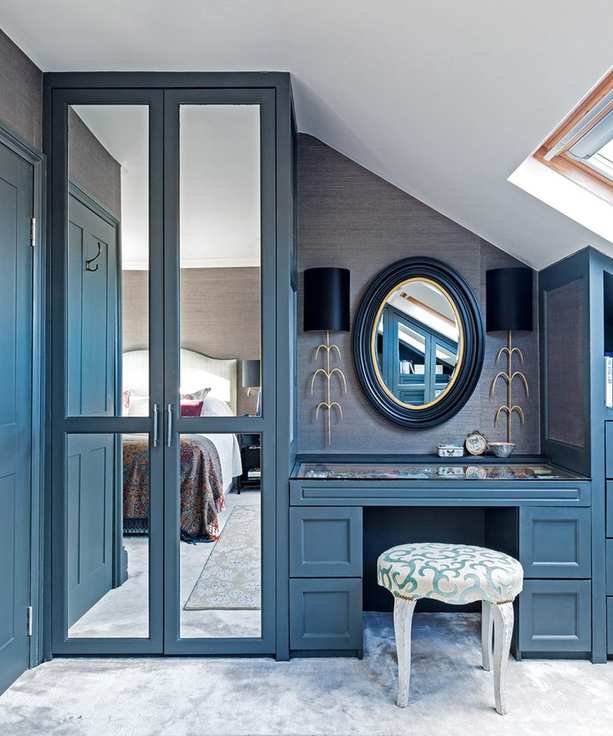 Blue built-in wardrobes serving as small bedroom storage.