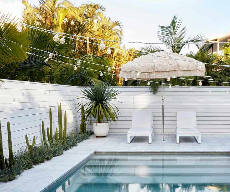 pool with festoon lights and sun loungers