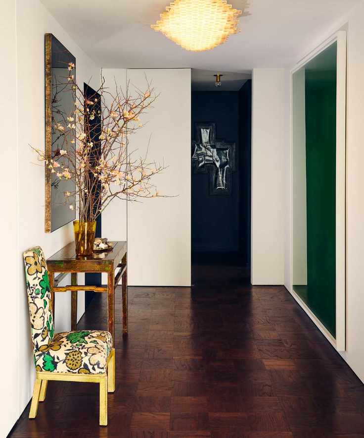 discovering your interior design style, entry way with hardwood floor, blossom branches in case, upholstered chair, mirrors