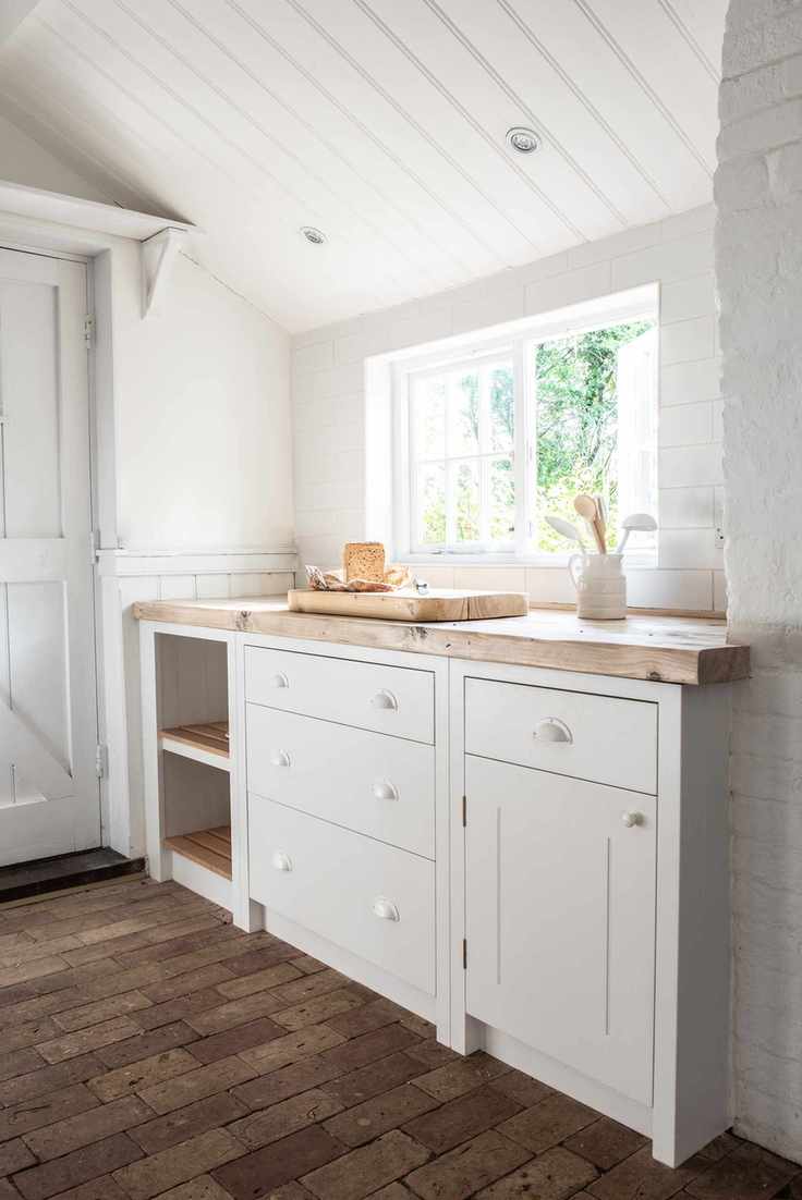 Mudroom with brickwork flooring, white cupboards and a picturesque window for ventilation