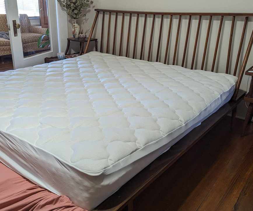 Wide angle of Helix Plush Mattress Topper on a bed.