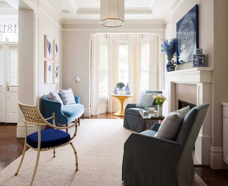 Beige living room with blue accents and a calming rug.