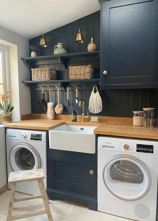 Laundry room with midnight blue cabinetry and wooden accents.