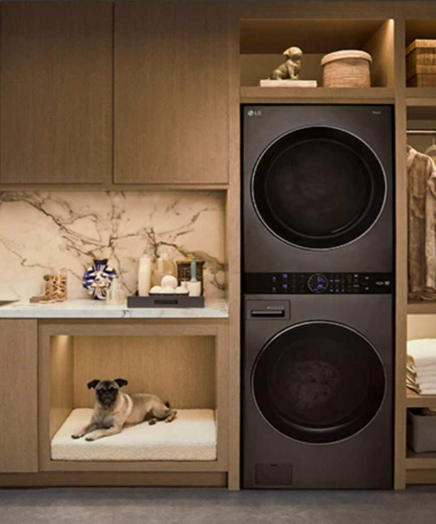 A stacked laundry set in an artificially lit laundry room