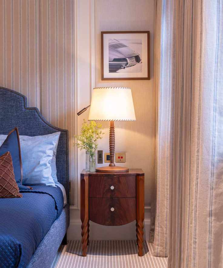Lamp shade on nightstand in classic bedroom with blue textiles
