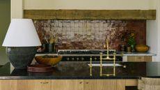 a contemporary meets rustic kitchen with oak cabinetry, rustic beams, and oxblood red zellige tile backsplash behind the range cooker 