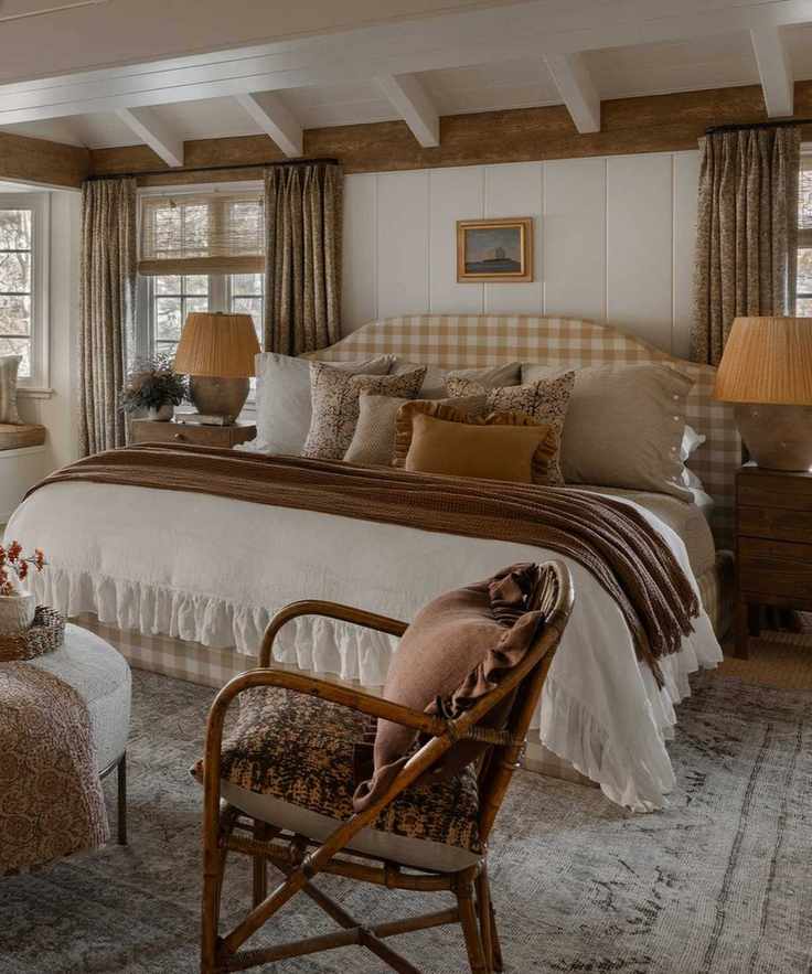 A cottage core bedroom with a bed adorned with pillows and a wooden accent chair