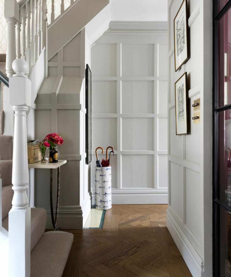 A bright entryway with wooden flooring and a small table decorated with flowers.