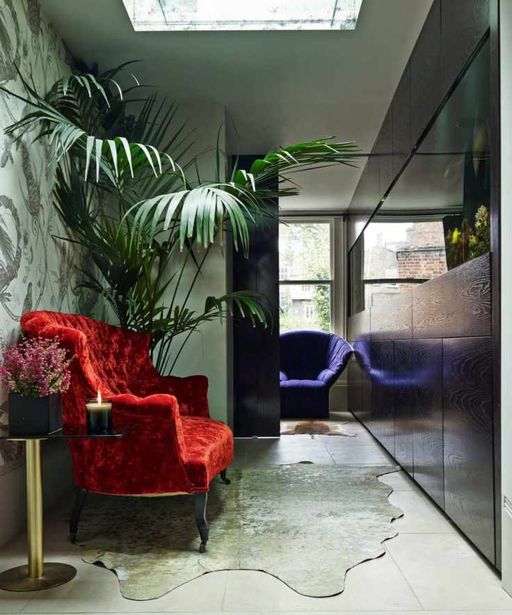 a hallway featuring an aquarium with a red chair and large plant