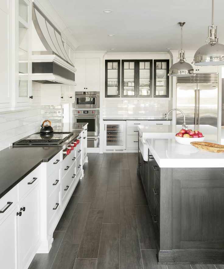 Chic white kitchen with dark wood island and glass cabinet