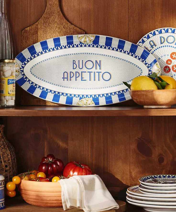 A wooden kitchen shelf filled with Bistro Tile Collection: Italia Edition plates and platters
