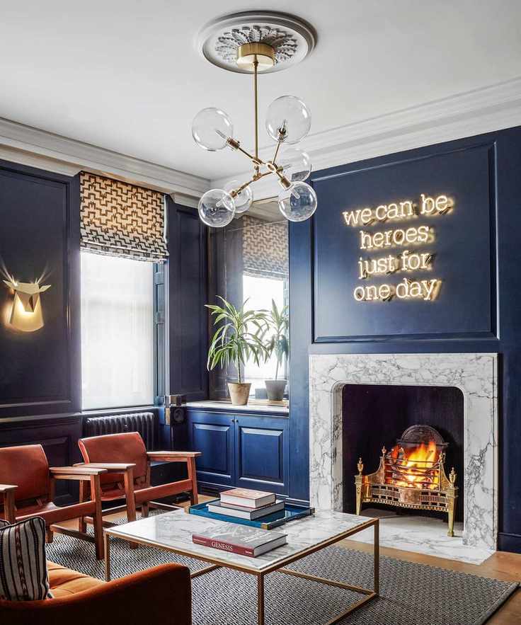 Gold globe sputnik chandelier, blue walls and neon wall light