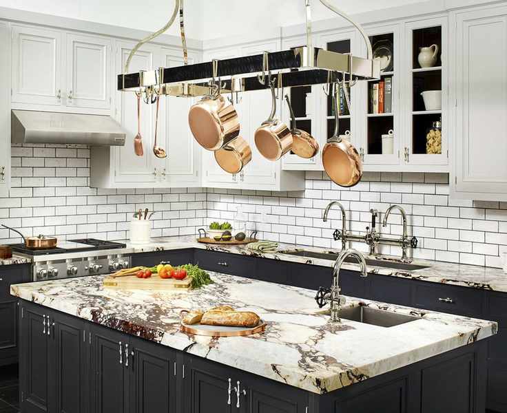 A black kitchen idea with black lower cabinets and island, and white upper cabinets and subway tiling