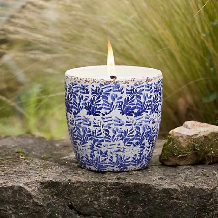 Blue and white porcelain candle with grasses and natural stone in background