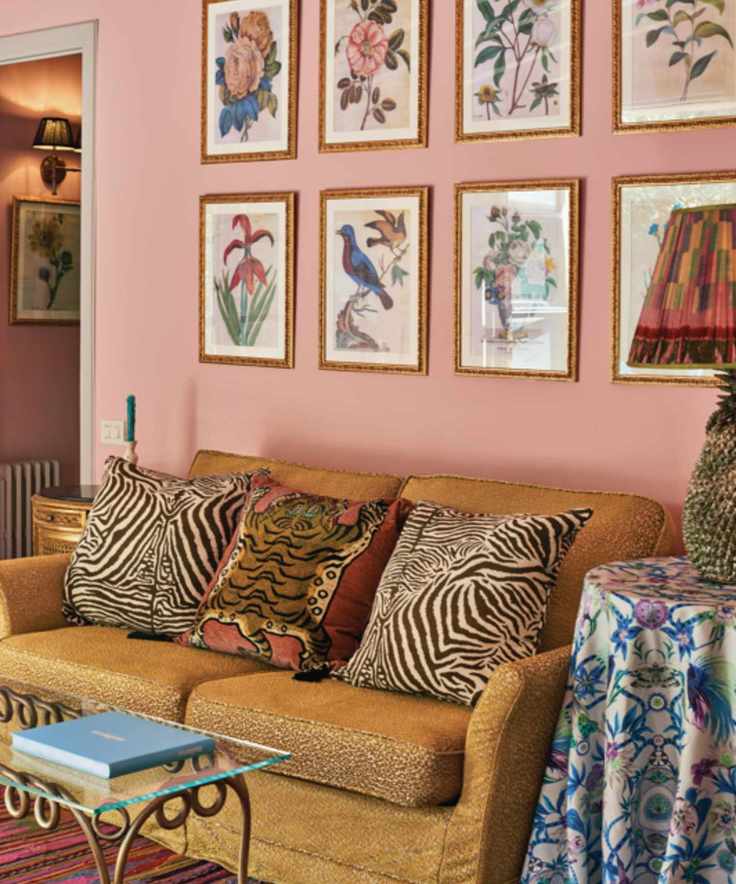 Pink room with animal print throw pillows and floral gallery wall is Belmond La Residencia