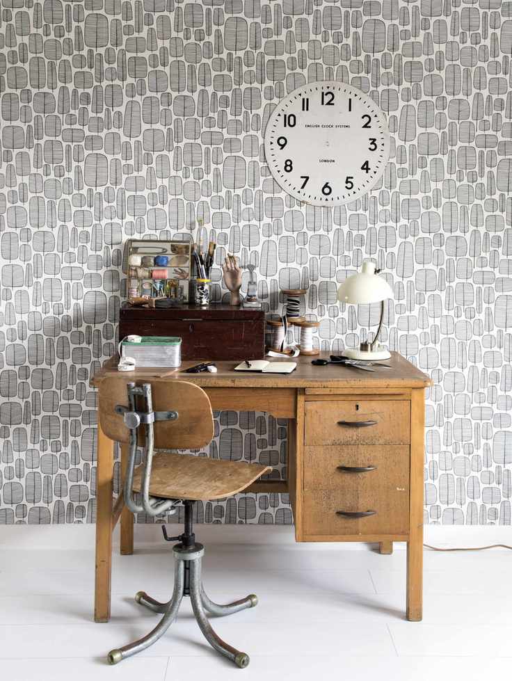 vintage desk with gray graphic Miss Print wallpaper, white floor, craft/sewing accessories and lamp on desk, vintage chair