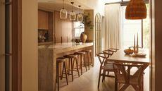 a European wabi-sabi style kitchen with oak cabinetry, floors, and furniture with a large rattan pendant