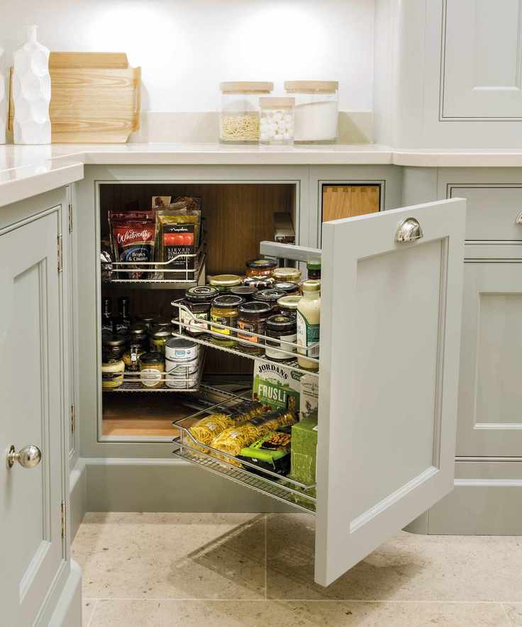 Kitchen cupboard storage ideas with a magic corner system in pale gray cabinetry.