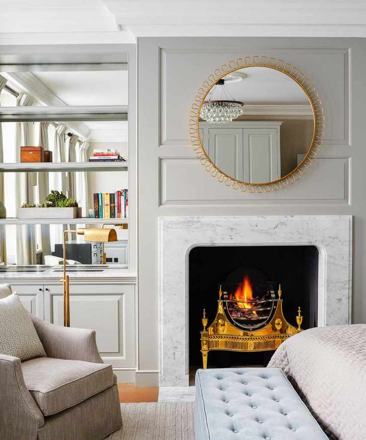 Bedroom in soft grey tones with a cozy fireplace