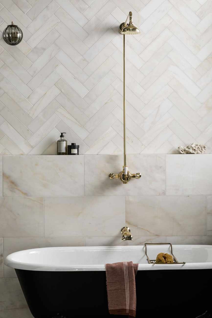 A brass shower above a freestanding bath illustrates how to choose a shower for a traditional scheme.
