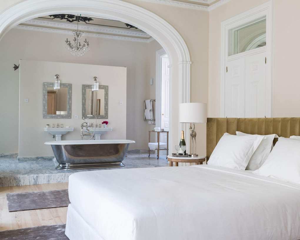 Large, luxurious open-plan bedroom and bathroom, bathroom on tiered marble level