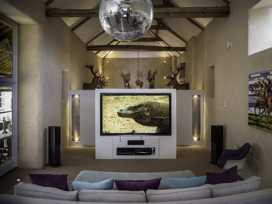large movie room in barn conversion, beams, glitter ball, tv/media centre, stag heads, seating