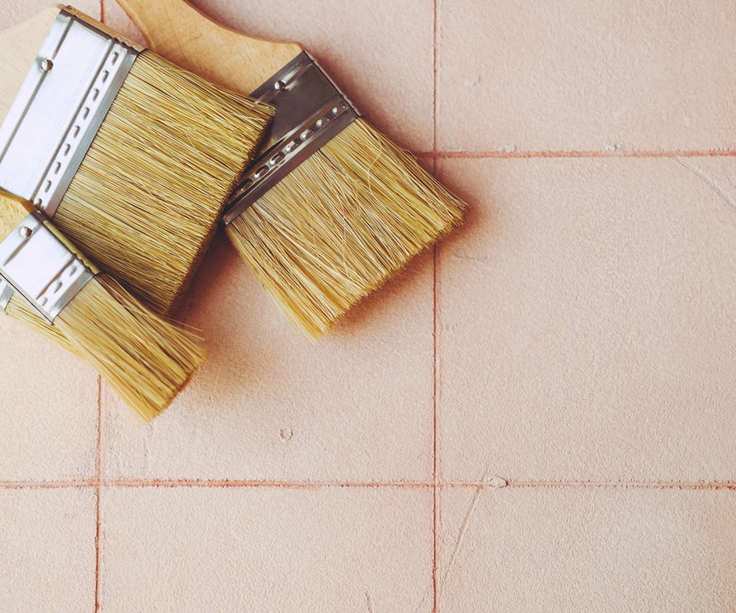 Pink tiles with paintbrushes laid on top