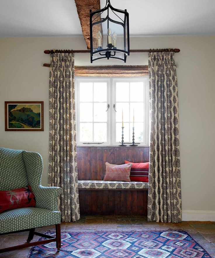 beamed hall with wooden windowseat, block printed curtains, green armchair and patterned rug