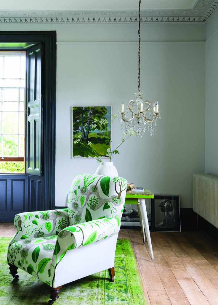 Living room with chair, wood floor and rug, white walls and small chandelier