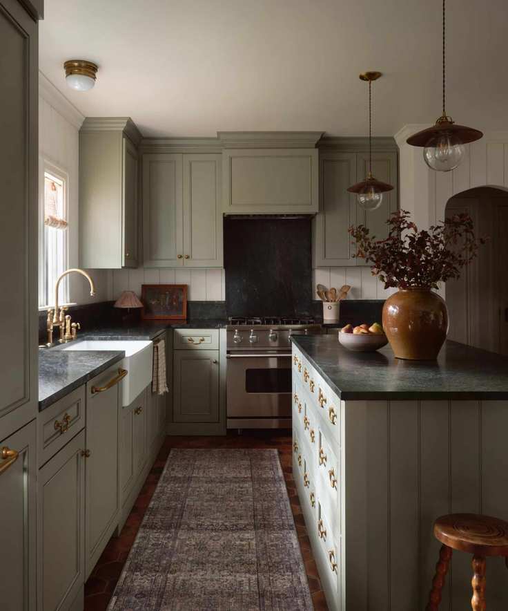 soft green small kitchen with dark marble countertops