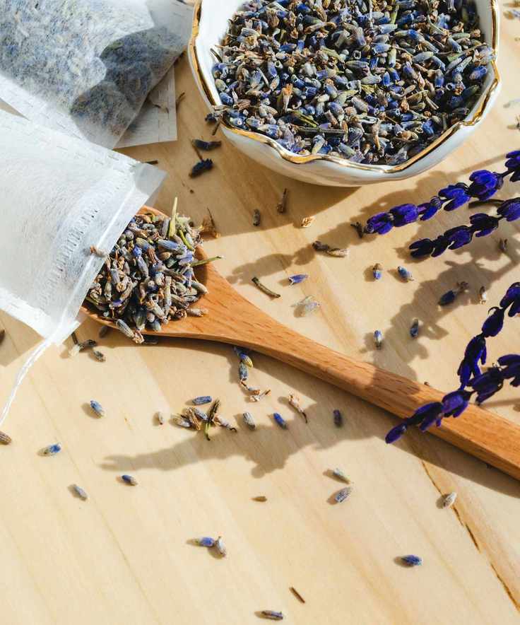 Lavender being spooned into a drawstring bag