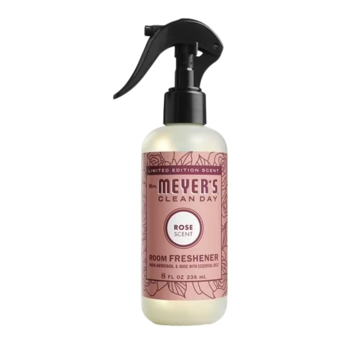 A clear spray bottle of Mrs. Meyer's rose room freshener with a black lid