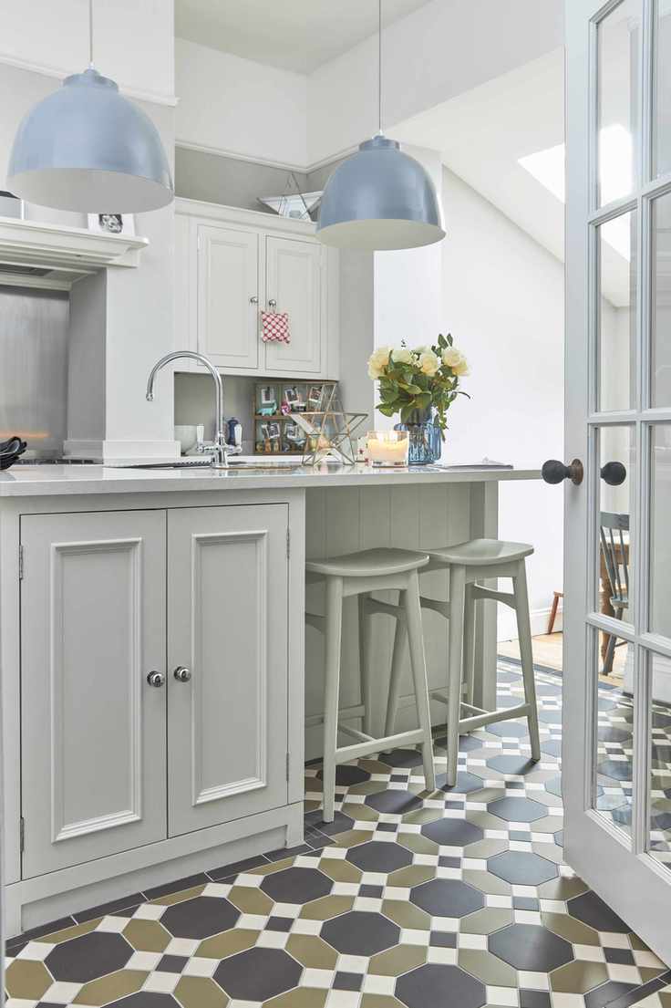 Victorian style tiling showcasing a neutral kitchen with blue pendant lighting.