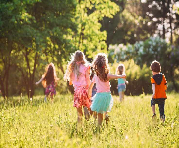 Children playing outside in a sunny field