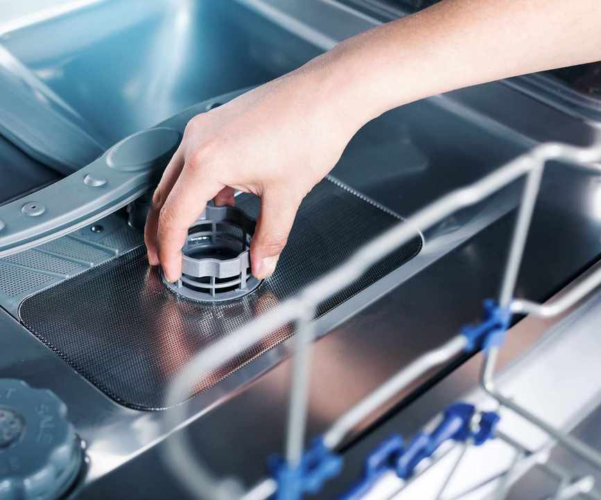 someone removing a dishwasher filter