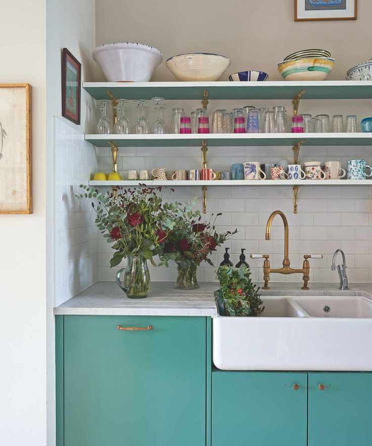 Blue cabinets in kitchen with shelves with vintage bowls, glasses and mugs