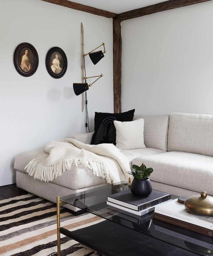 family room with white painted walls, cream l-shape sofa and black cushions and lamp