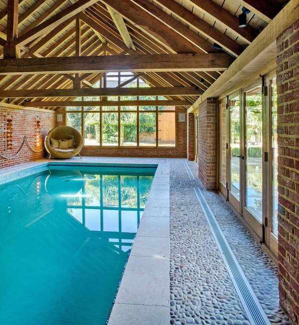 An example of pool landscaping ideas showing an indoor pool with wooden beams