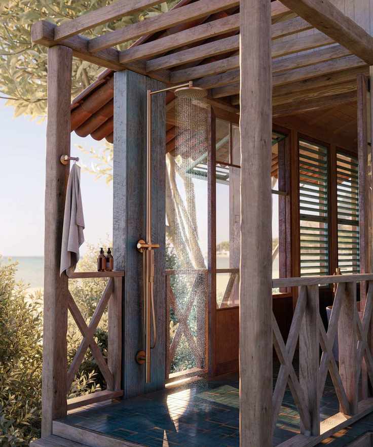 An outdoor shower surrounded by a wood frame with brass hardware