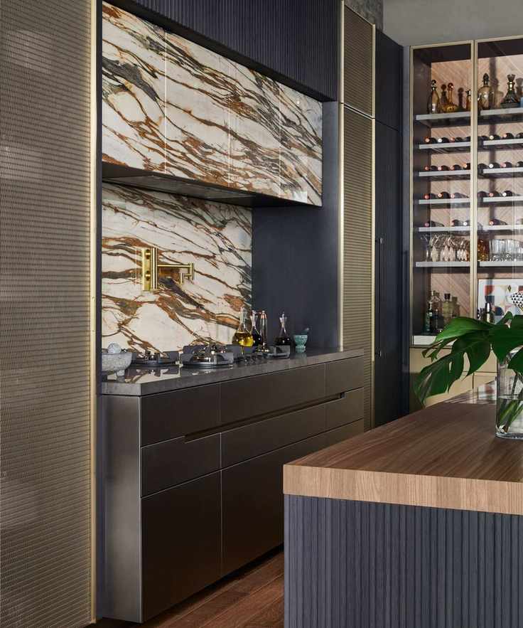 A modern moody kitchen with a striking natural stone backsplash