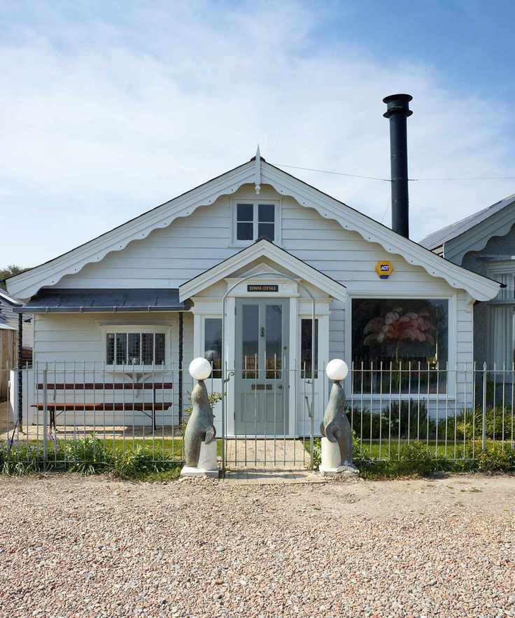 Modern metal gate shown in a beach side wooden clad property.