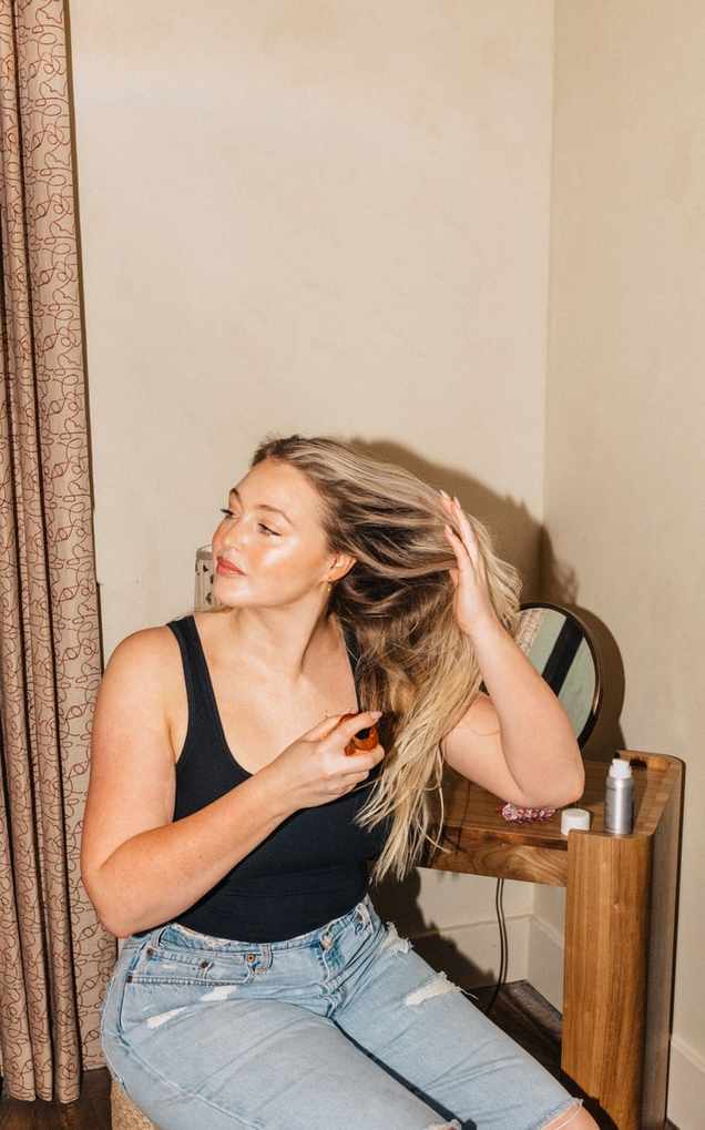 Woman styling blonde hair.